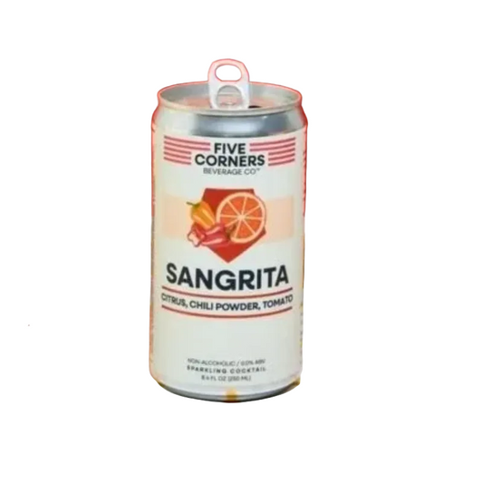 A can of Five Corners Sangrita sparkling cocktail mix stands on a white tiled counter with yellow grid lines. The can is white with red and orange graphics, surrounded by a basket of lime and red chili peppers on the left, and a glass of orange-colored drink with a lime wedge on the right, against a solid red background.