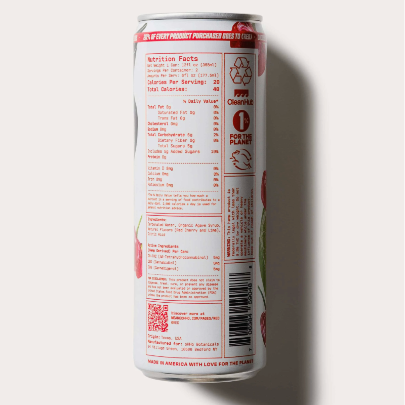 A tall aluminum beverage can shown upright against a plain light background, displaying the back panel with nutrition facts, ingredients, and a barcode. The can is white with red text and graphics, and a small green leaf illustration appears near the lower right edge.