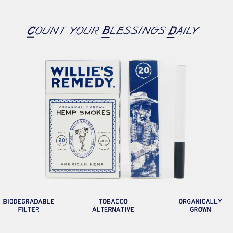 A product lineup on a light gray background featuring a box of Willie's Remedy Hemp Smokes, a matching blue pack, and a single rolled cigarette with a biodegradable filter. Text above reads 'COUNT YOUR BLESSINGS DAILY' and text below lists product benefits: 'BIODEGRADABLE FILTER', 'TOBACCO ALTERNATIVE', and 'ORGANICALLY GROWN'.