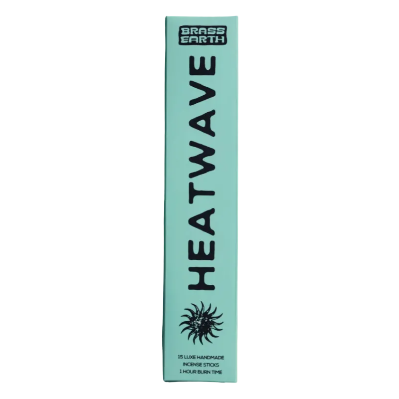 A tall, narrow mint green box for Brass Earth Heatwave hair dye stands upright against a matching mint green background. The box features bold black text reading 'HEATWAVE' vertically, a black sunburst logo near the bottom, and the Brass Earth brand logo at the top.