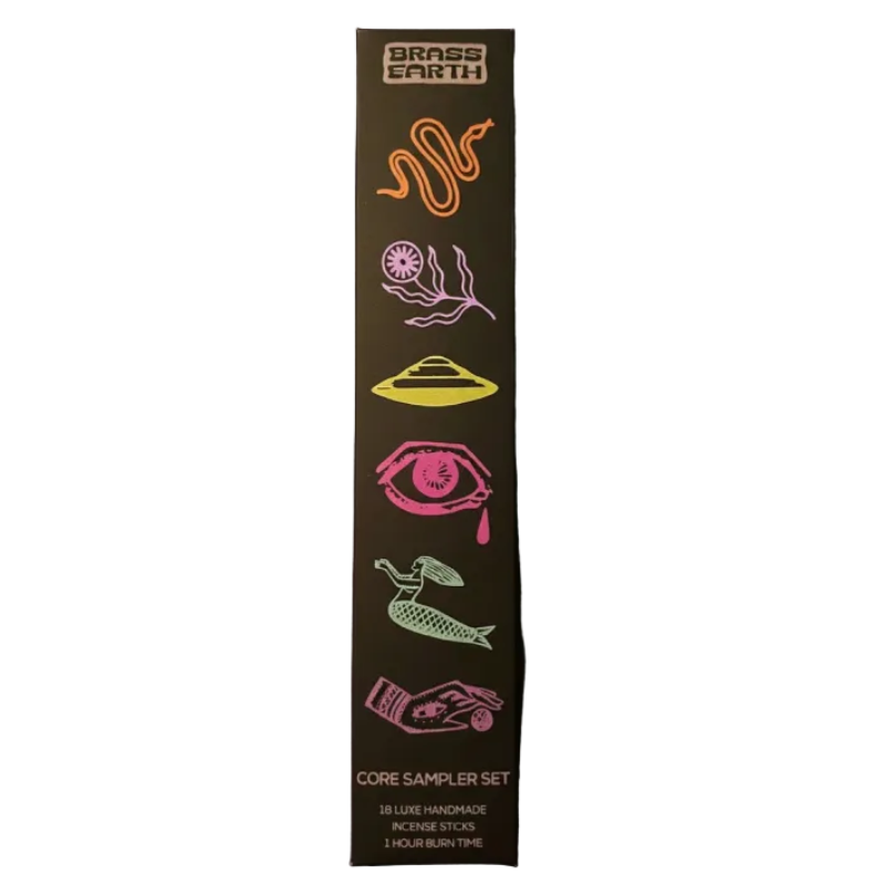 A tall, narrow black product box for the Brass Earth Core Sampler Set, featuring colorful neon-style illustrations of a snake, flower, UFO, eye, mermaid, and hands on a purple background.